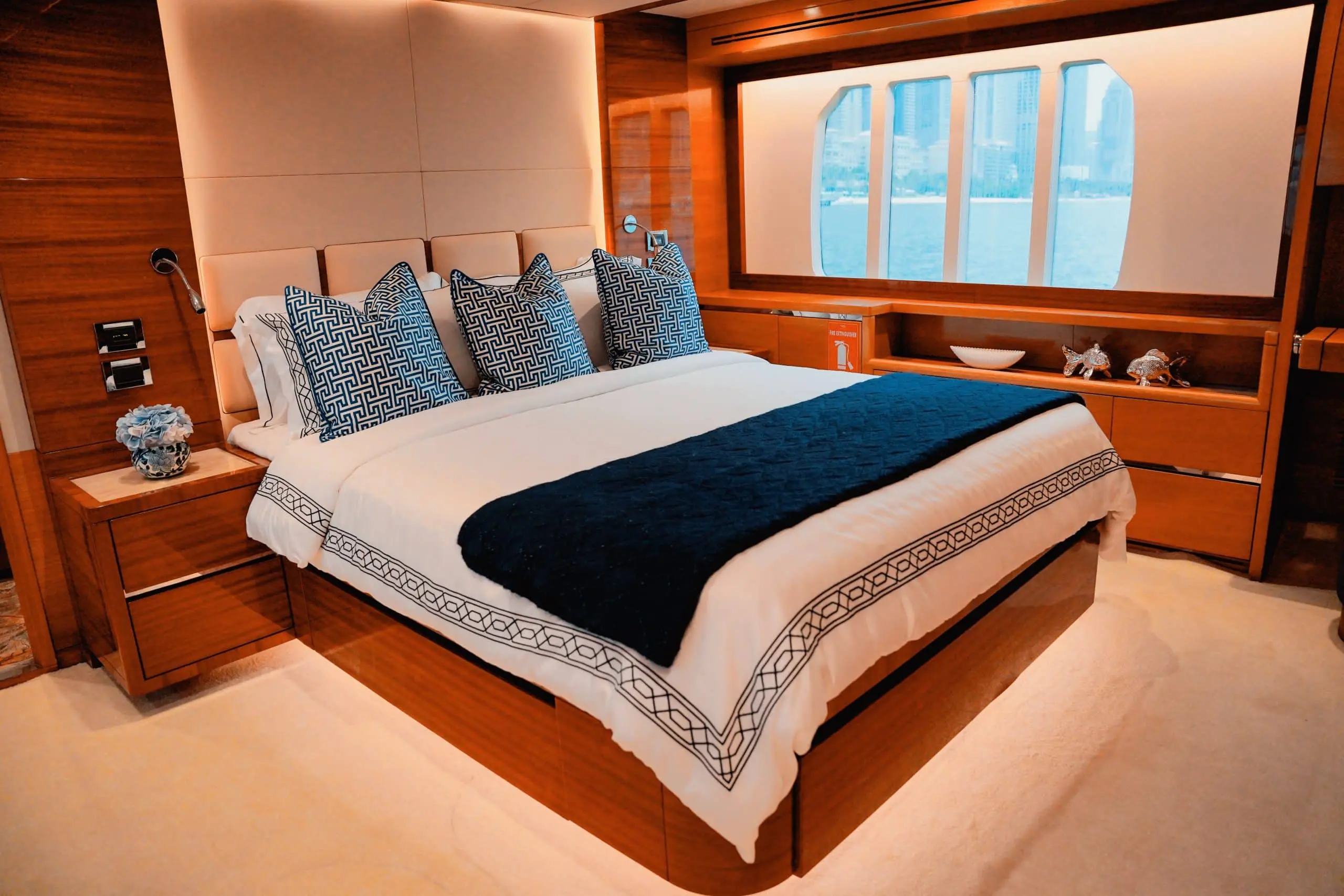 Master bedroom cabin on Carina 75 yacht with king-size bed and wooden interior