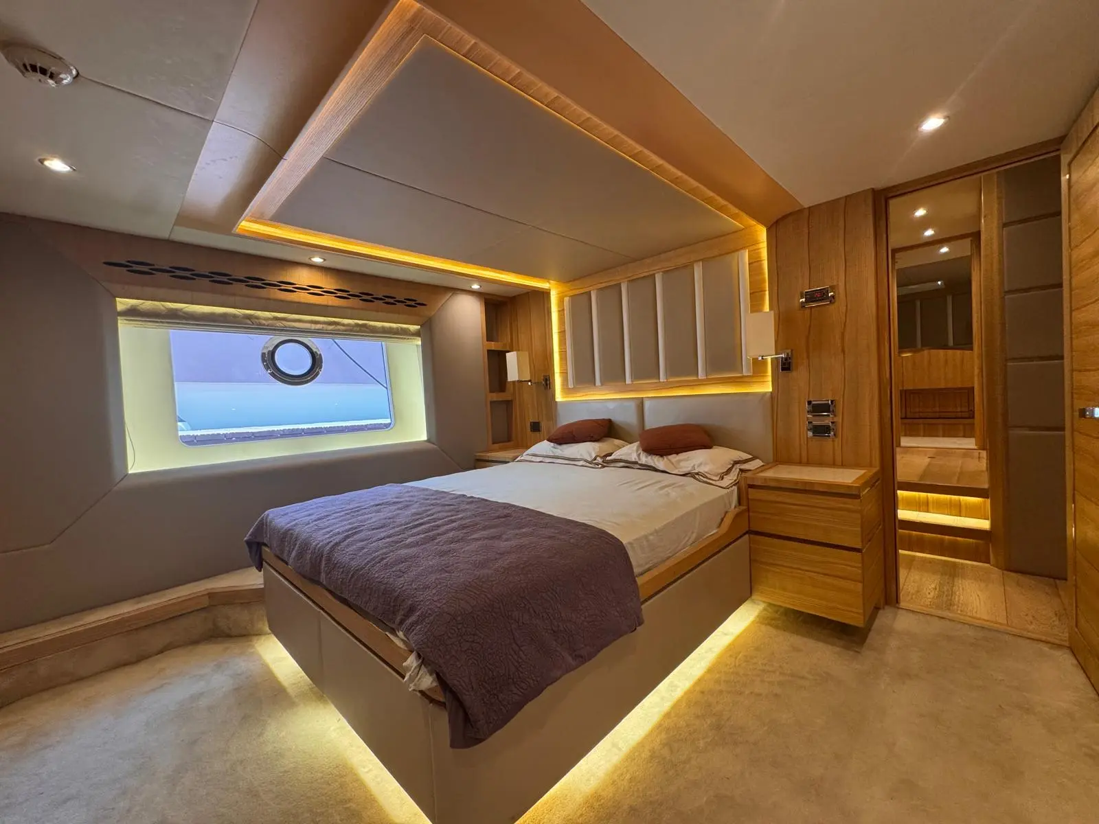 Nomad 65 guest double cabin with hull window and warm lighting