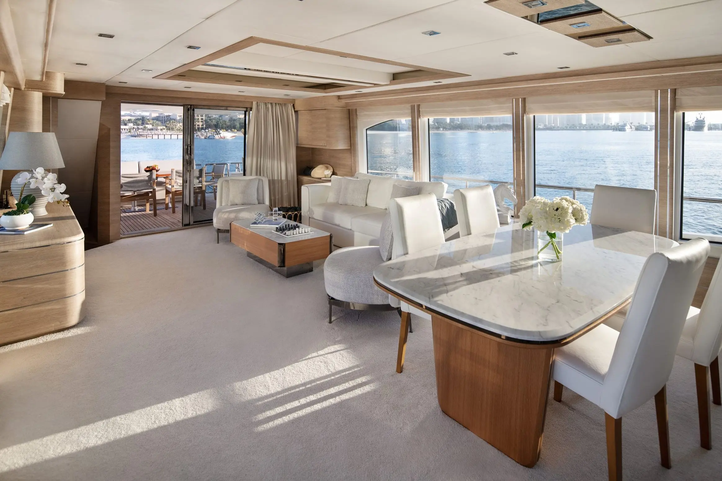Private yacht main salon with modern seating and large windows in Dubai