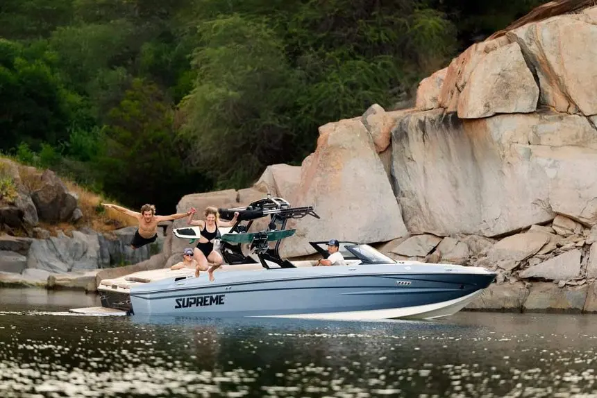 Supreme S240 bow view resting by a rocky cove — press photo
