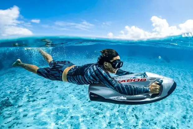 Person snorkeling with underwater sea scooter in clear ocean