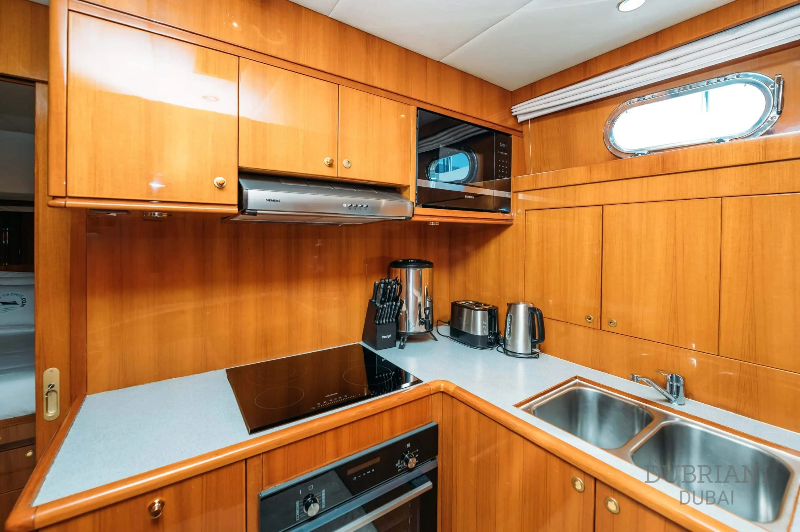 Fully equipped galley kitchen on Eclipse yacht with wooden cabinetry and modern appliances