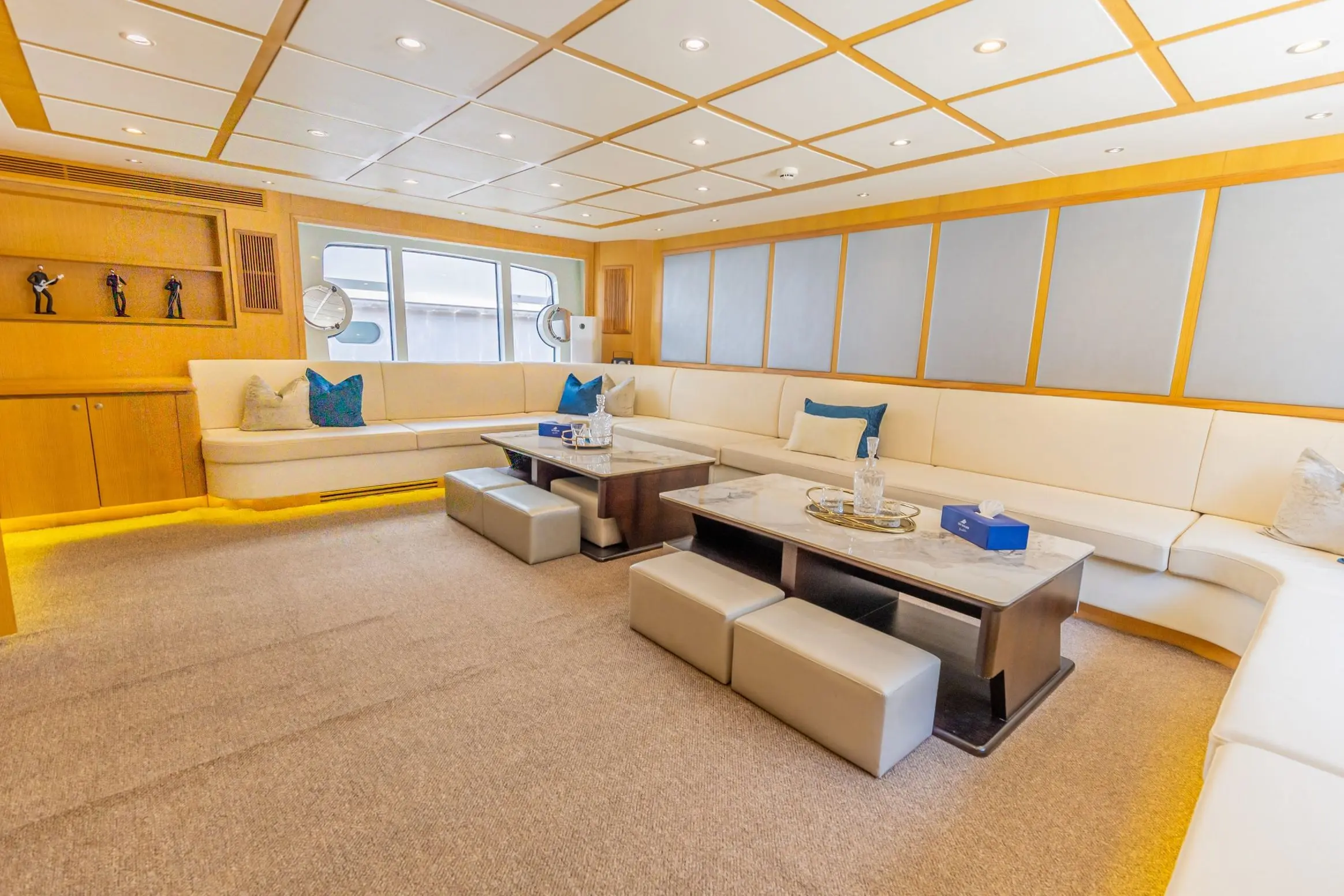 Asya 110 yacht spacious main salon with L-shaped sofa and wooden ceiling design
