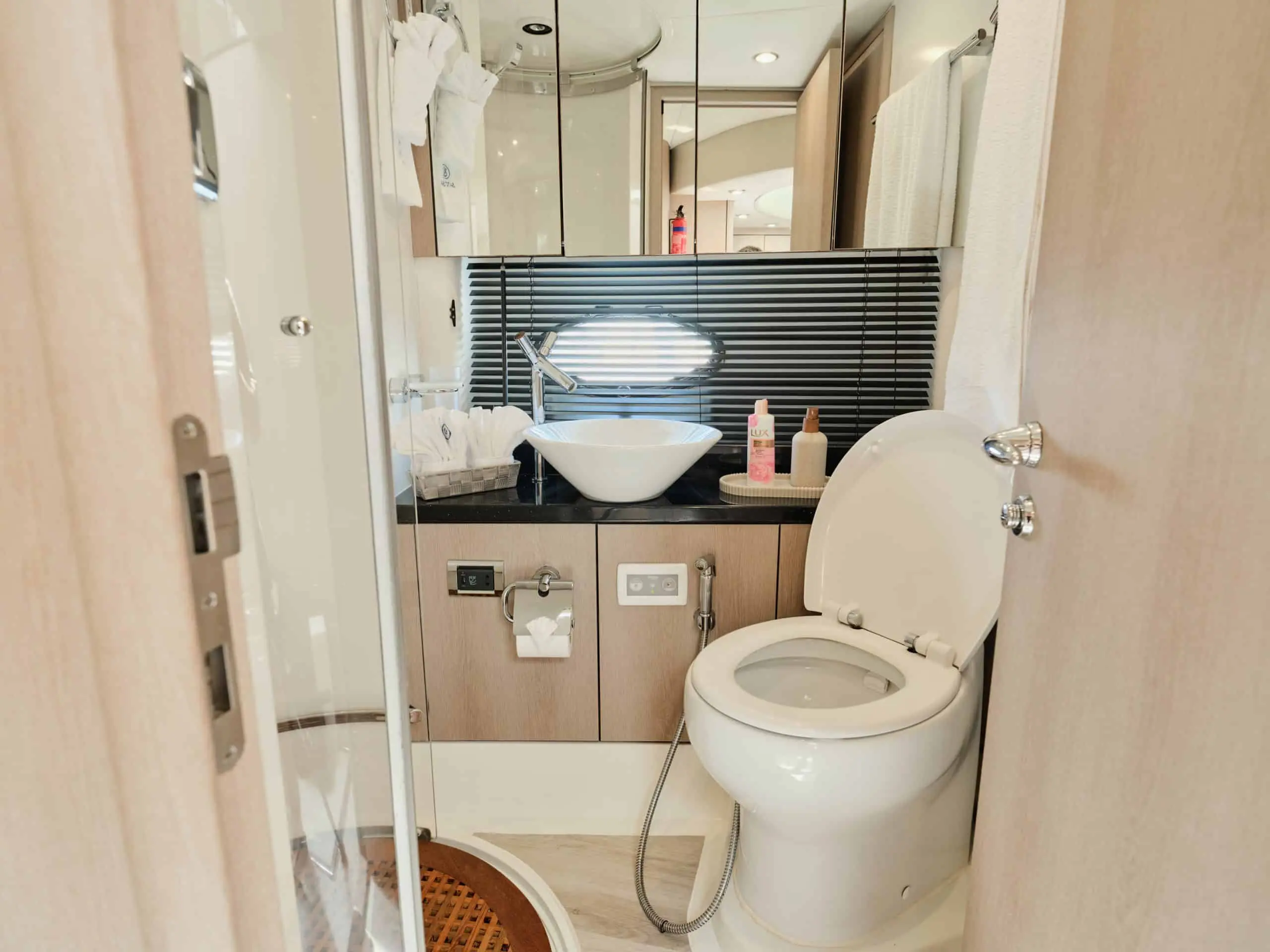 Sunseeker Satoshi 70 yacht bathroom with modern sink, mirror, and enclosed shower