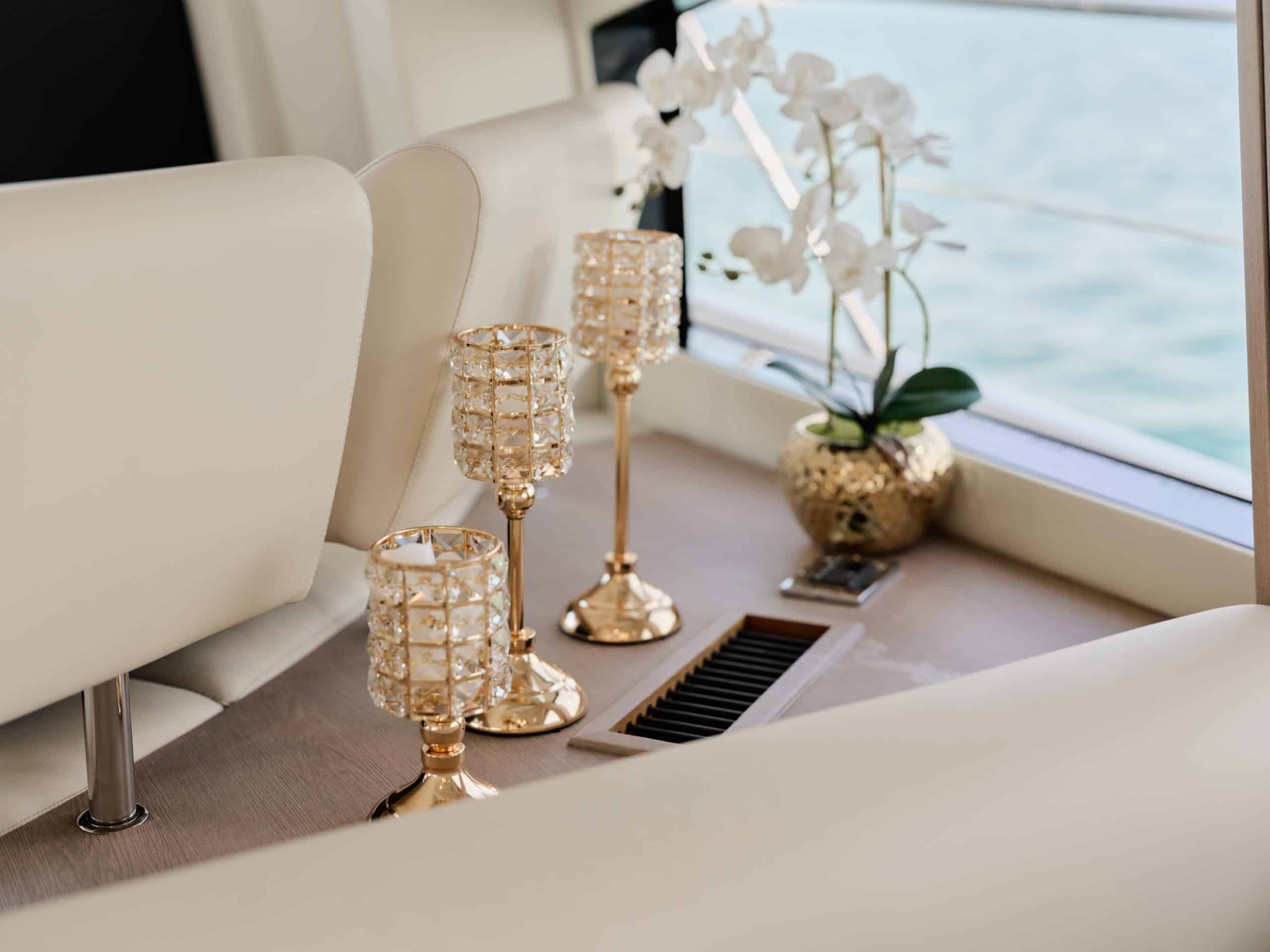 Elegant yacht interior décor with orchid arrangement and gold candle holders