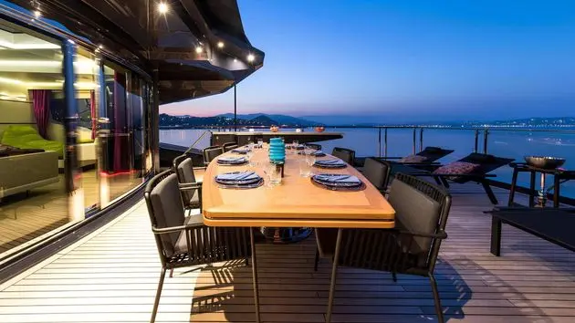 SuperSport 48 aft deck dining at dusk with lounge seating