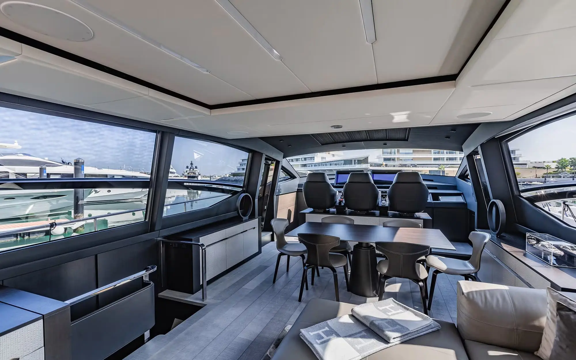 Pershing 8X main saloon with dining table and helm seats ahead
