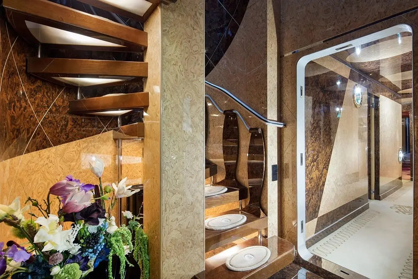 Thunder Superyacht spiral staircase with wooden steps and luxury interior design