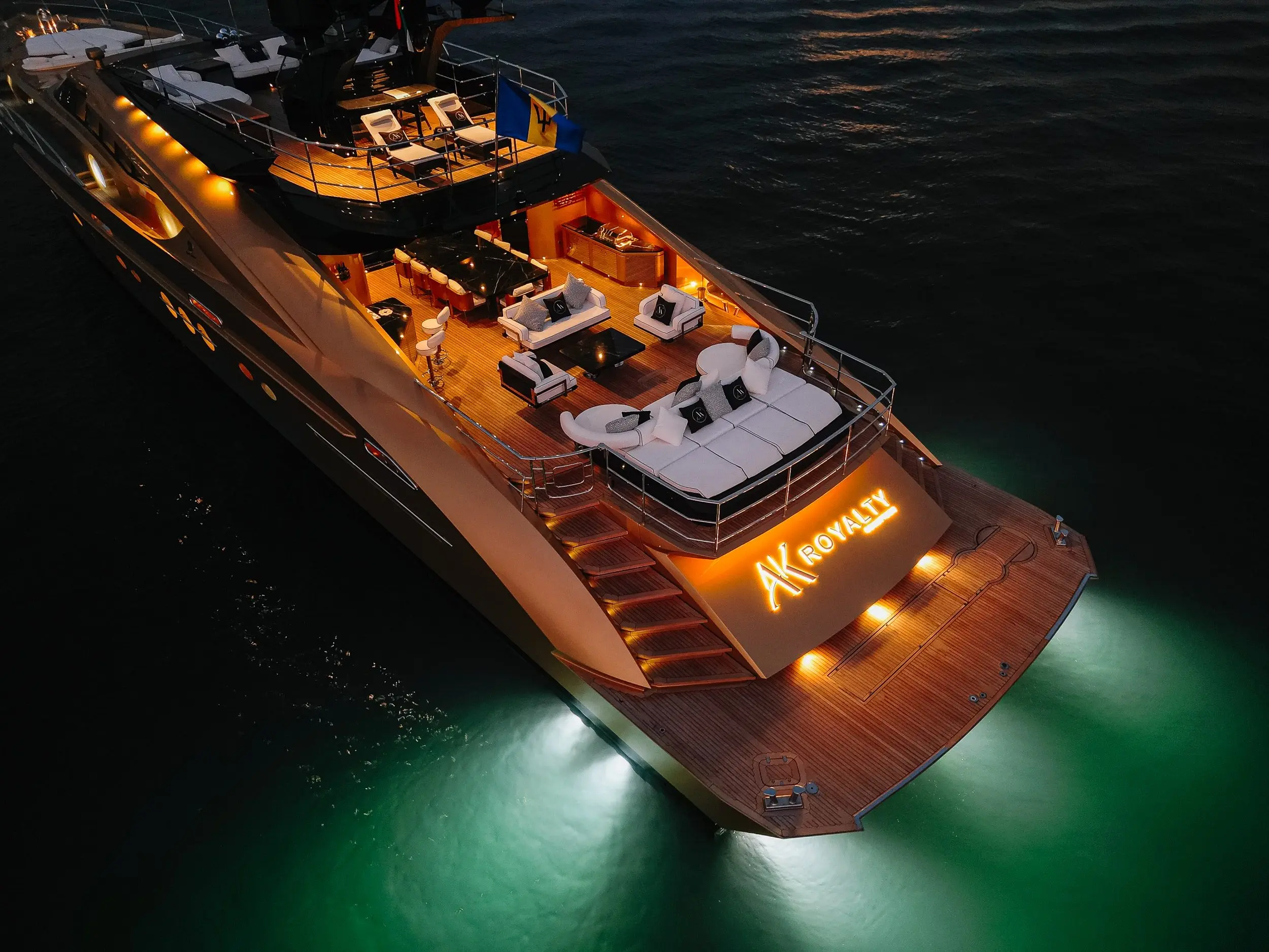 Royalty 136 luxury yacht illuminated at night with underwater lights glowing in the ocean