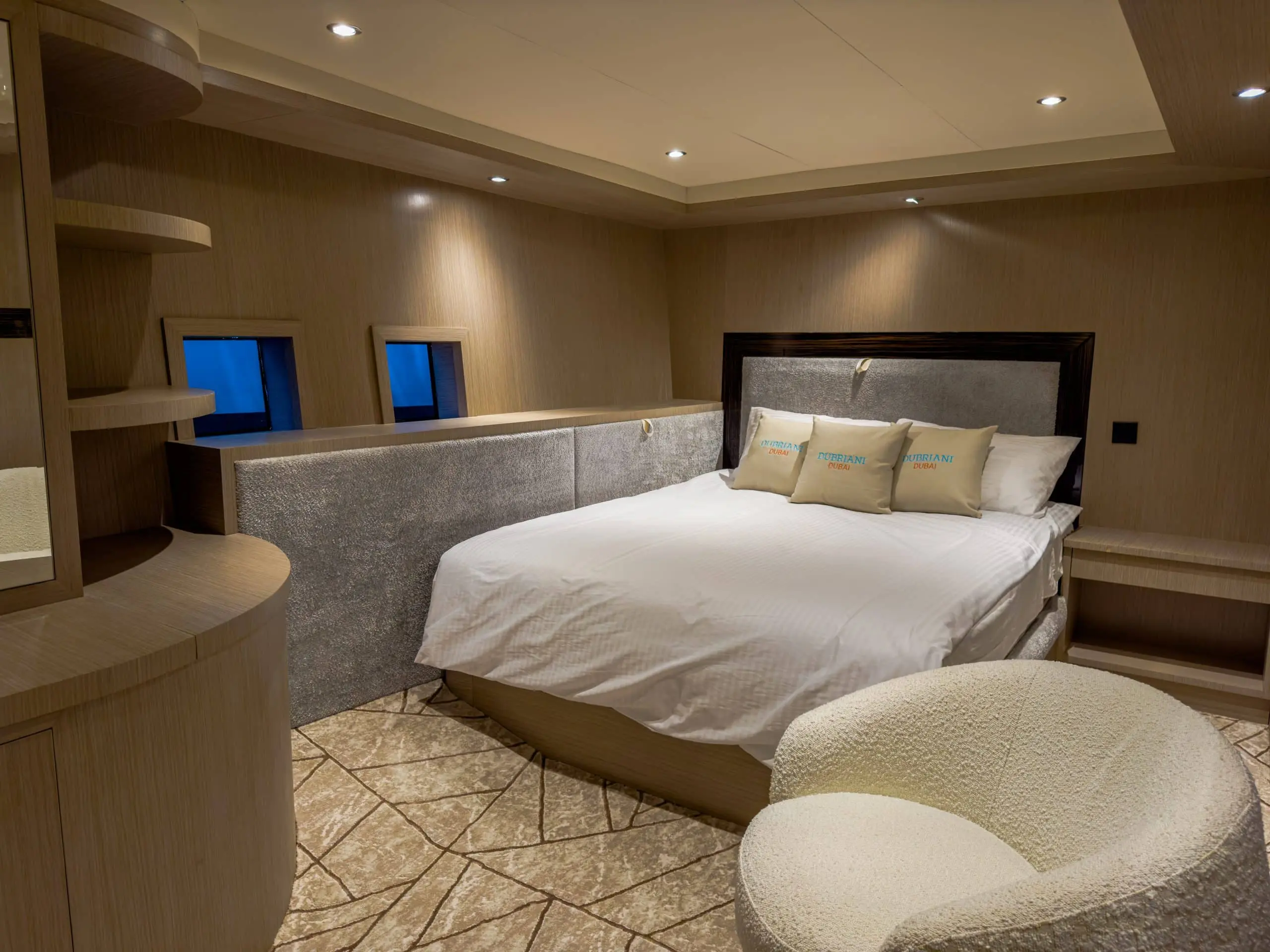 Luxury yacht bedroom with large bed, soft lighting, and twin wall screens