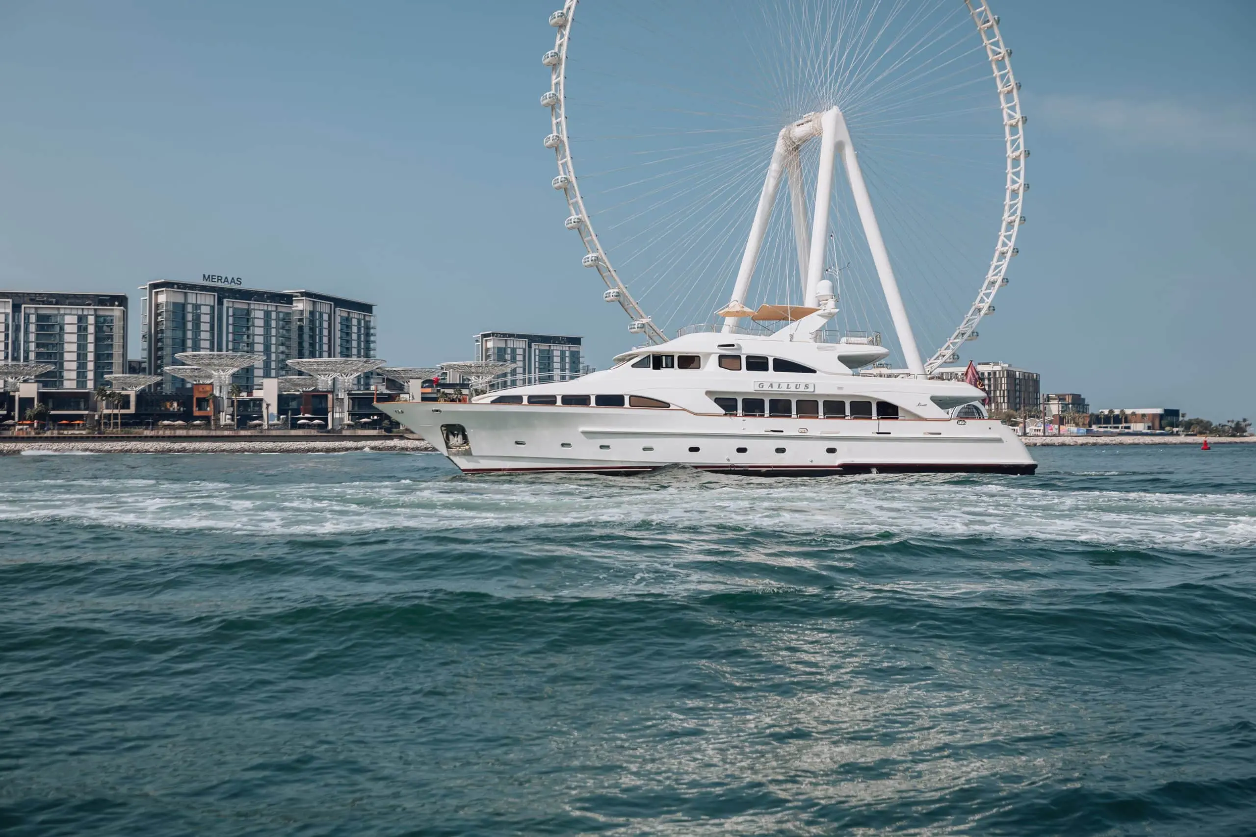 Luxury yacht cruising past Ain Dubai in Dubai.