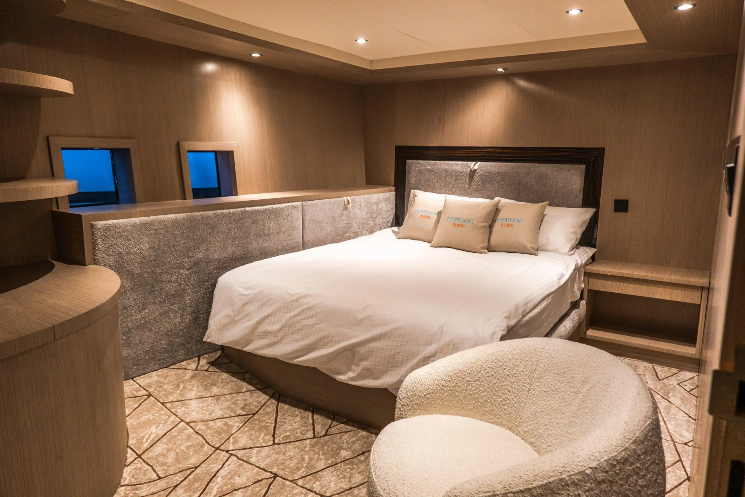Spacious yacht bedroom with large bed and stylish beige interiors