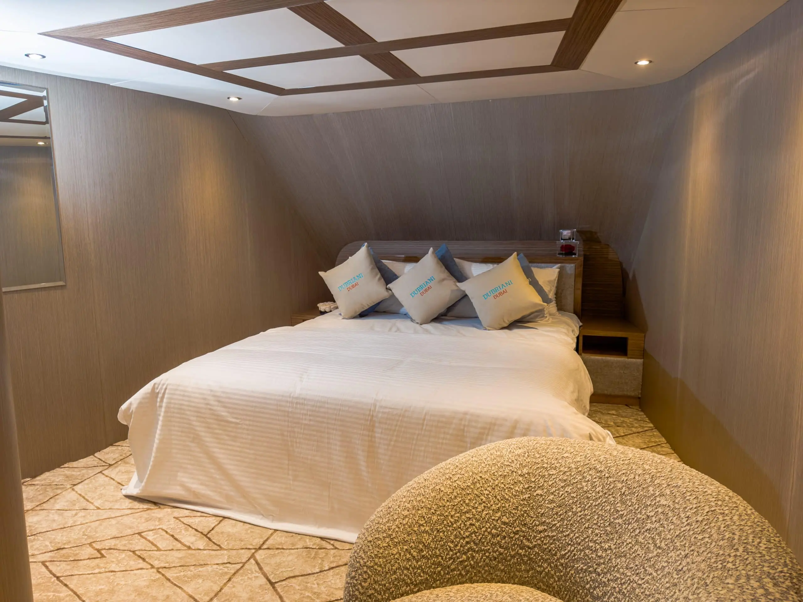 Elegant yacht bedroom featuring wooden ceiling accents and soft-toned décor