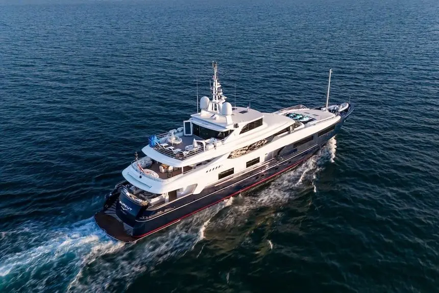 Aerial view of the 54m Baglietto superyacht cruising across deep blue open water leaving a white wake