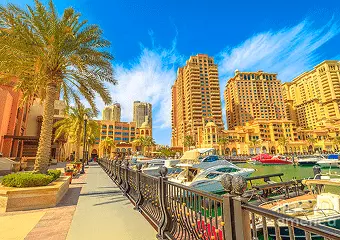 Sunny Dubai Marina promenade with yachts and waterfront skyline