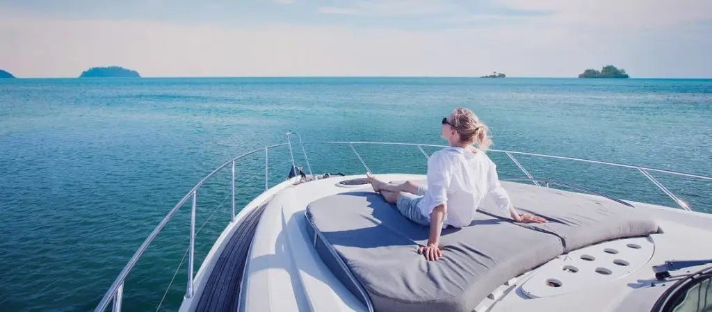 Woman relaxing on luxury yacht sun deck overlooking calm ocean