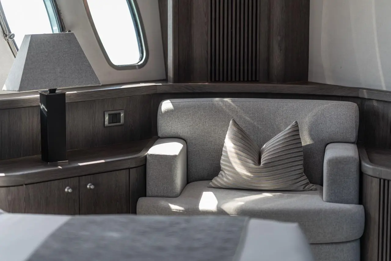 Sunseeker 82 Yacht master cabin lounge area with striped cushions