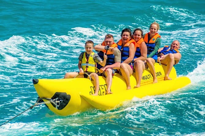 Group enjoying banana boat ride on turquoise sea during Dubai watersports activity