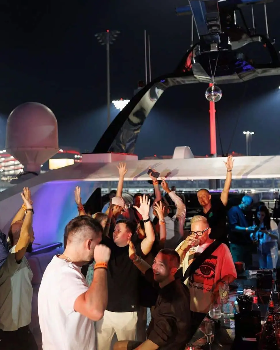 Guests dancing and celebrating at luxury yacht party with live DJ