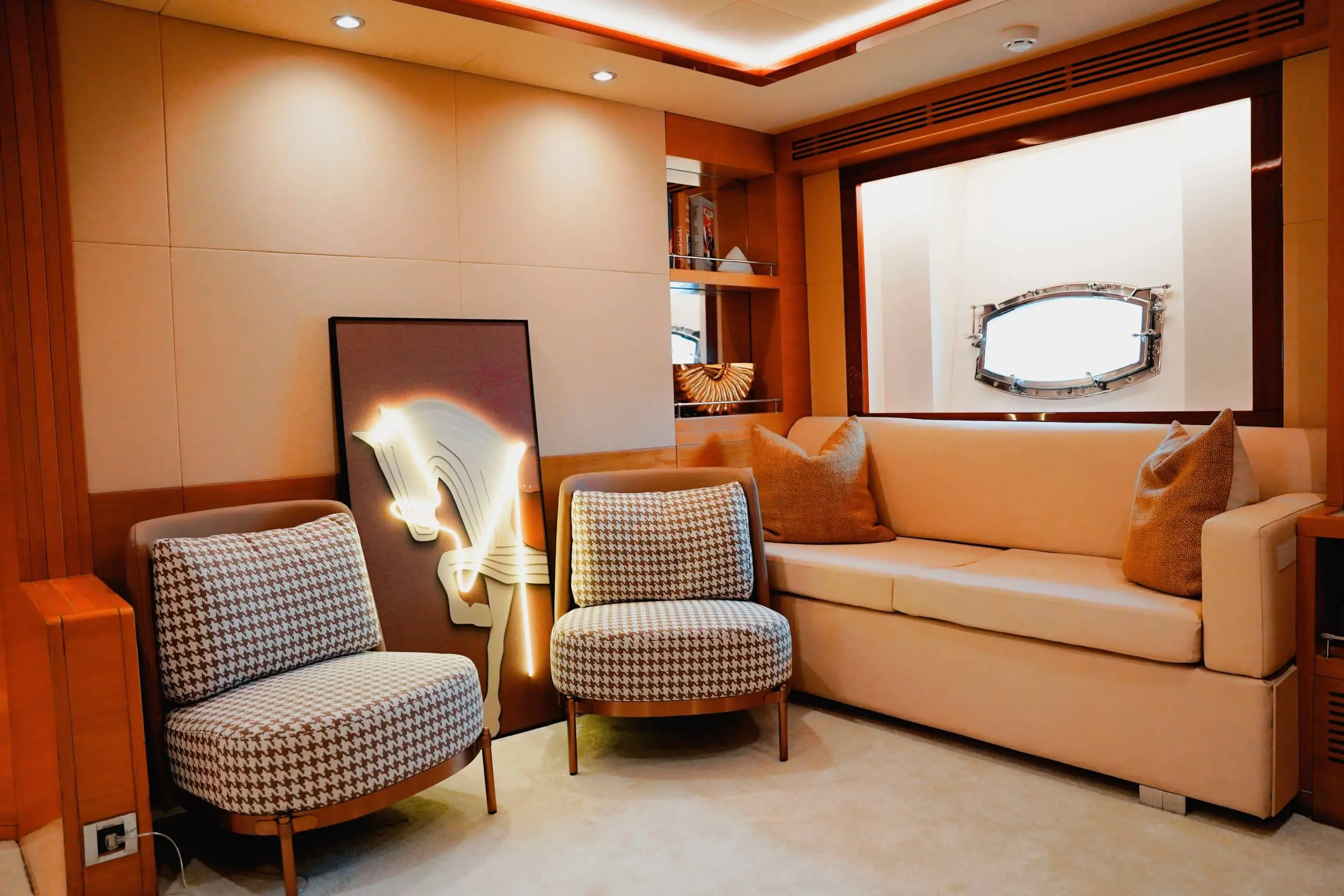 Carina 75 yacht interior lounge with beige sofa and modern armchairs
