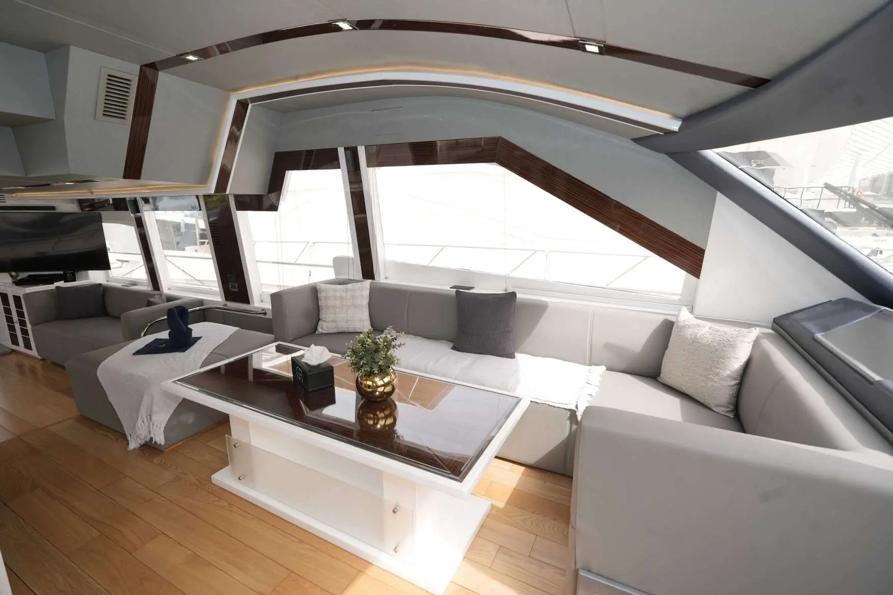 Belle 75 yacht salon with grey sofa and glass coffee table.