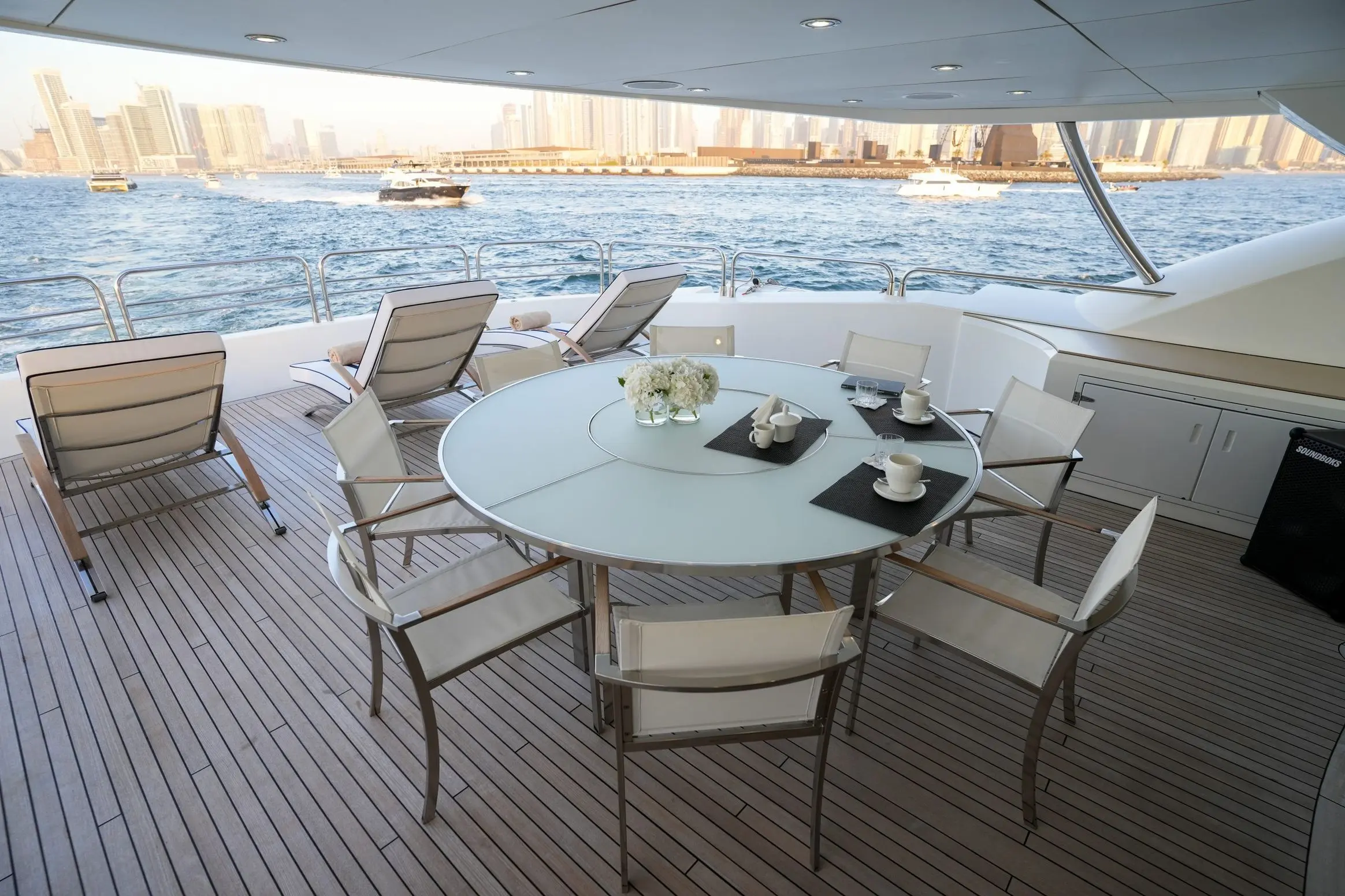 Large round dining table on Sunseeker 131 yacht deck with skyline backdrop