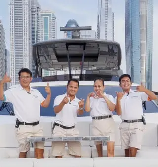 Professional crew of yacht posing on deck in Dubai Marina