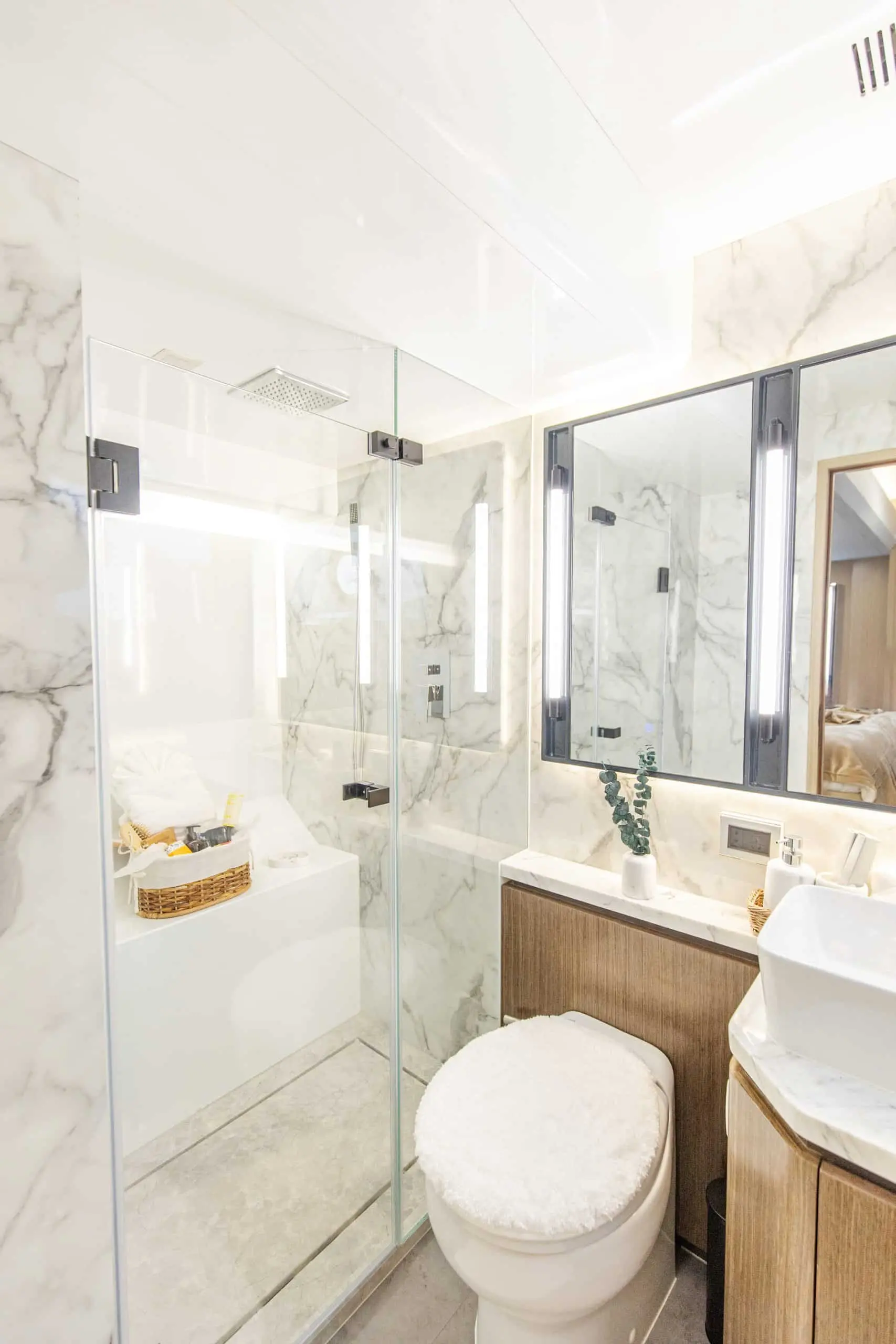 Zirve 72 yacht bathroom with marble walls, glass shower cabin and modern vanity
