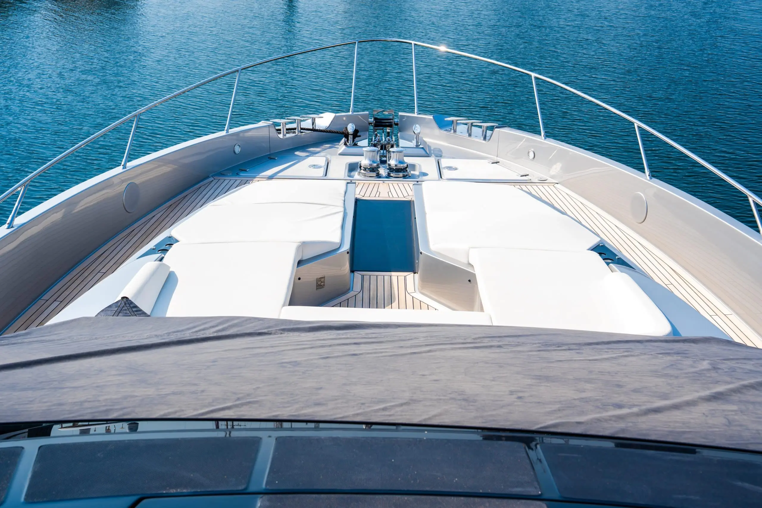 Bow sun deck with white loungers and teak decking on a luxury yacht
