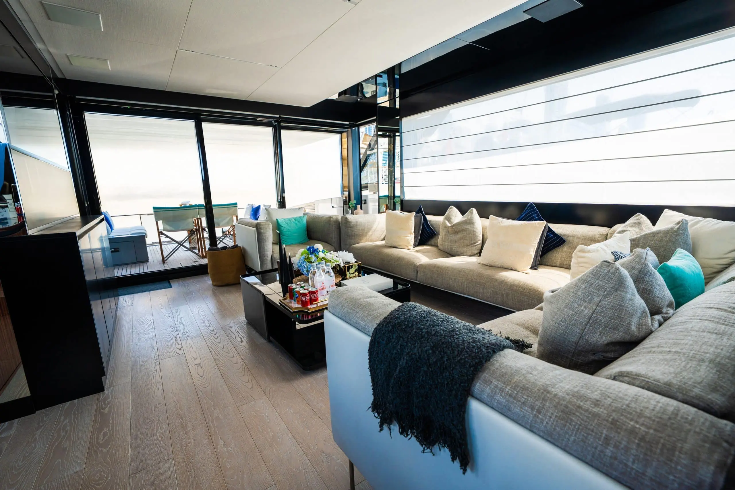 Riva 82 F1 yacht interior lounge with large sectional sofa, modern coffee table, and sliding glass doors to aft deck