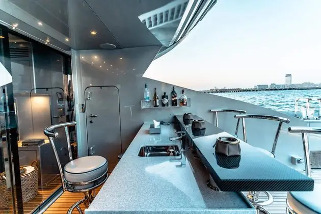 Baglietto 105 HT aft deck wet bar with stools and sea view