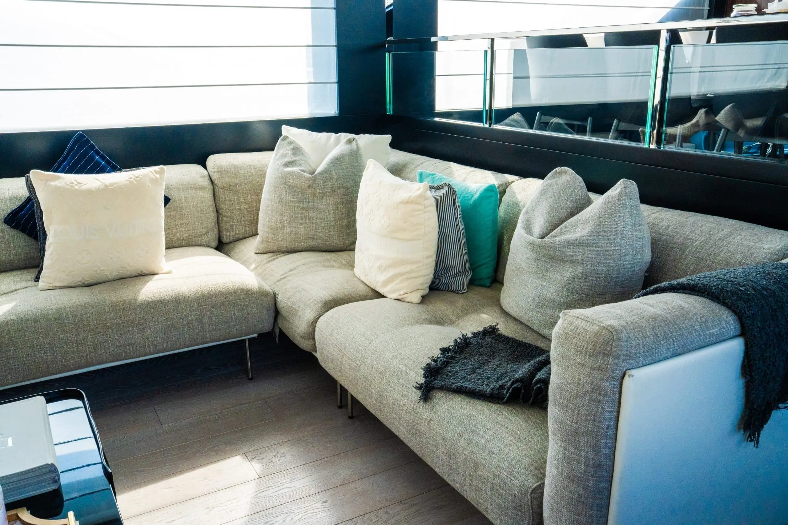 Corner sectional sofa with decorative pillows inside a luxury yacht lounge