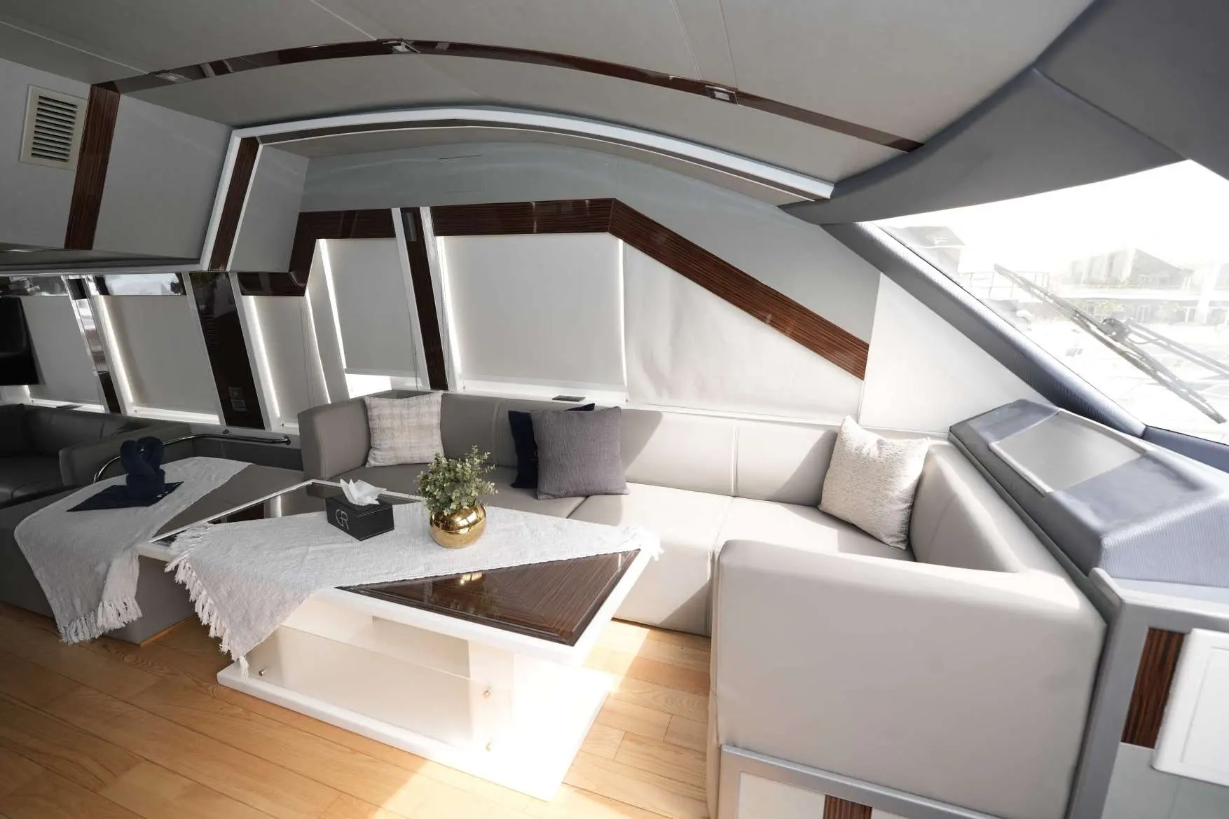 Luxury salon interior of Belle 75 yacht by Dubriani featuring cream leather seating, wooden finishes, and panoramic windows in Dubai.