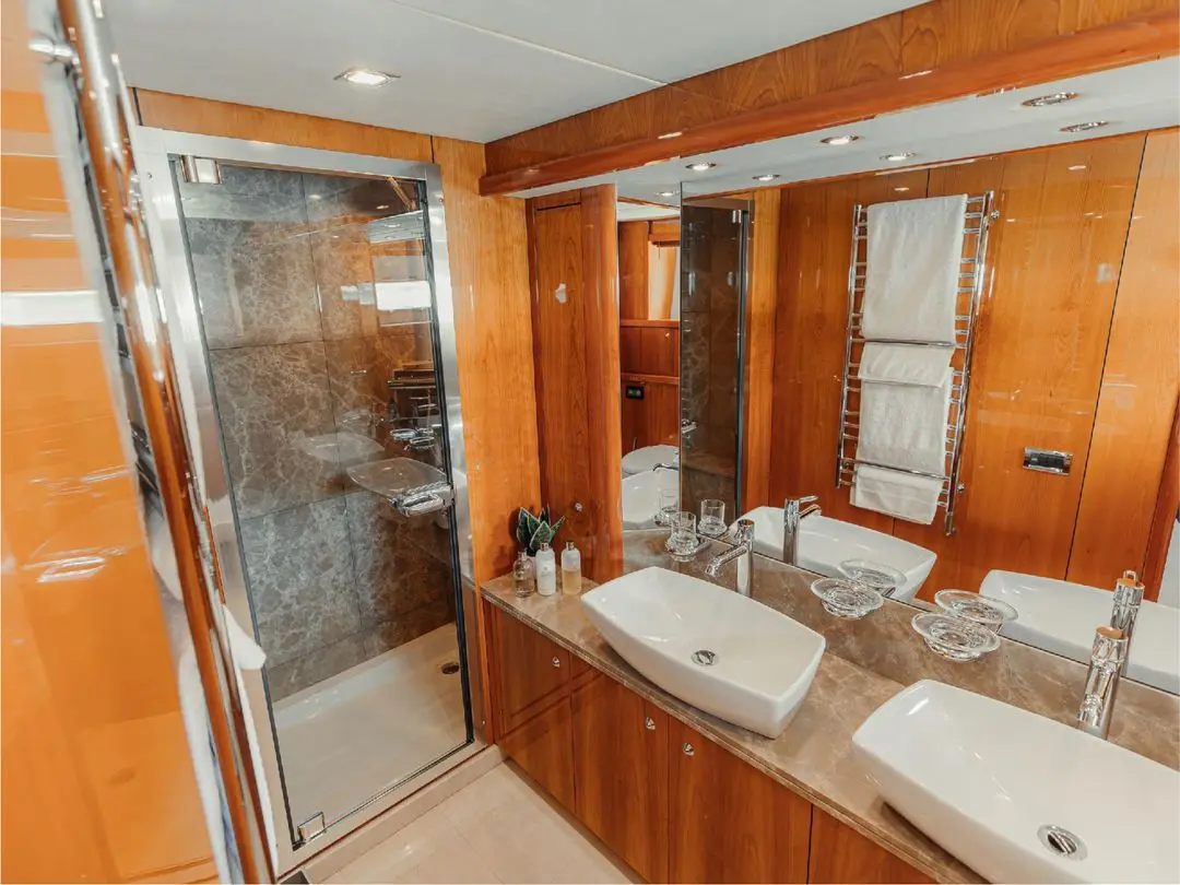 En-suite bathroom on Notorious yacht with glass shower and double sink