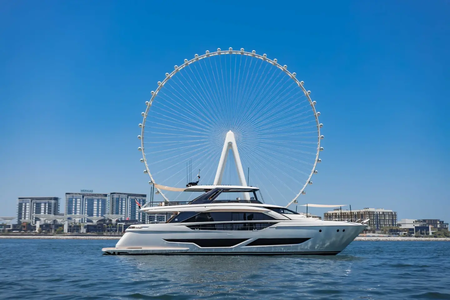 Ferretti 860 side profile at anchor with Ain Dubai and Bluewaters behind