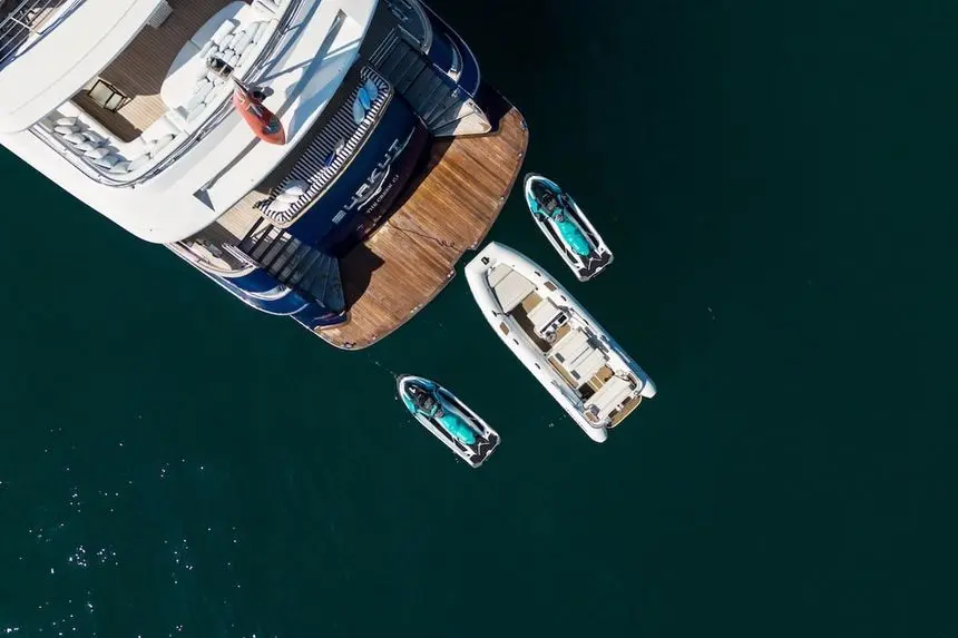 Overhead view of the 54m Baglietto swim platform with three tenders tied alongside in deep green water