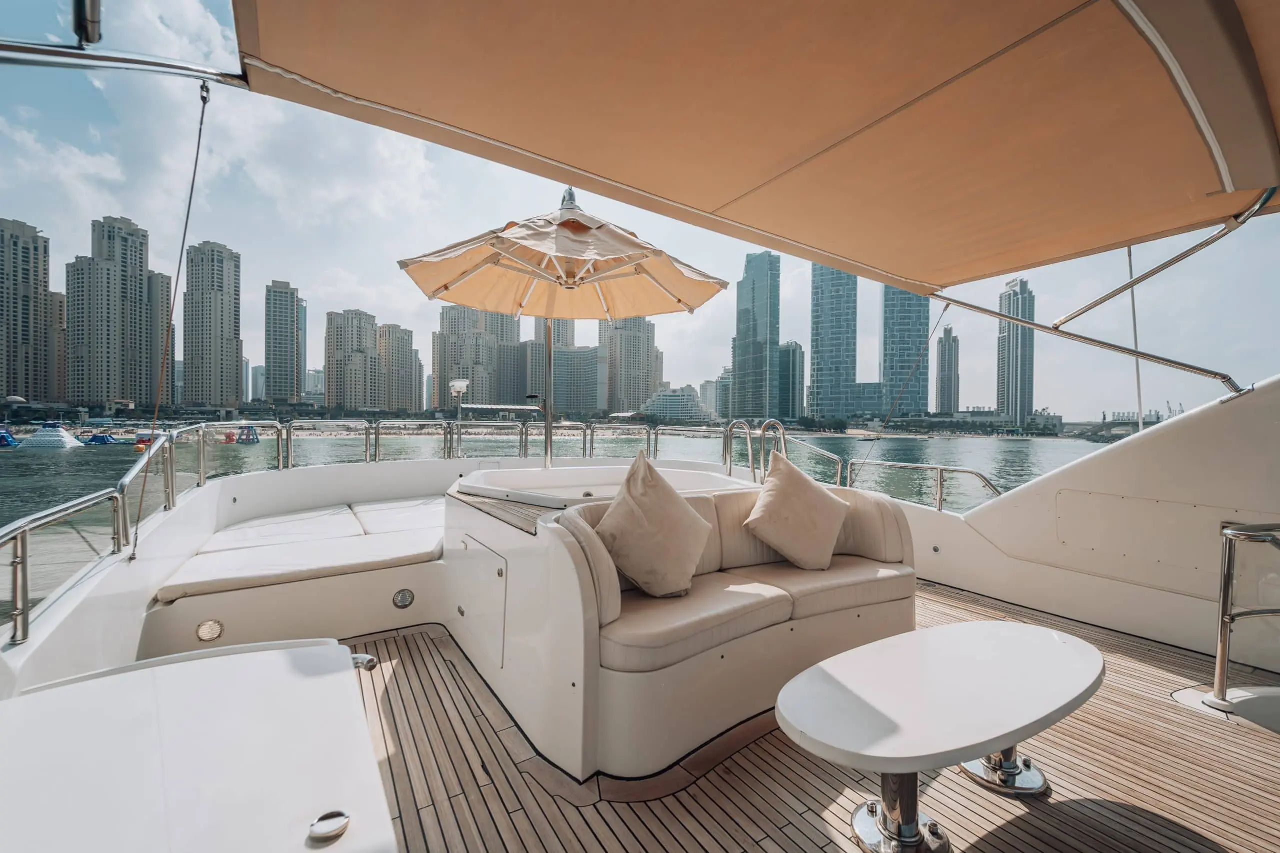 Shaded lounge seating on a luxury yacht with a city skyline view.