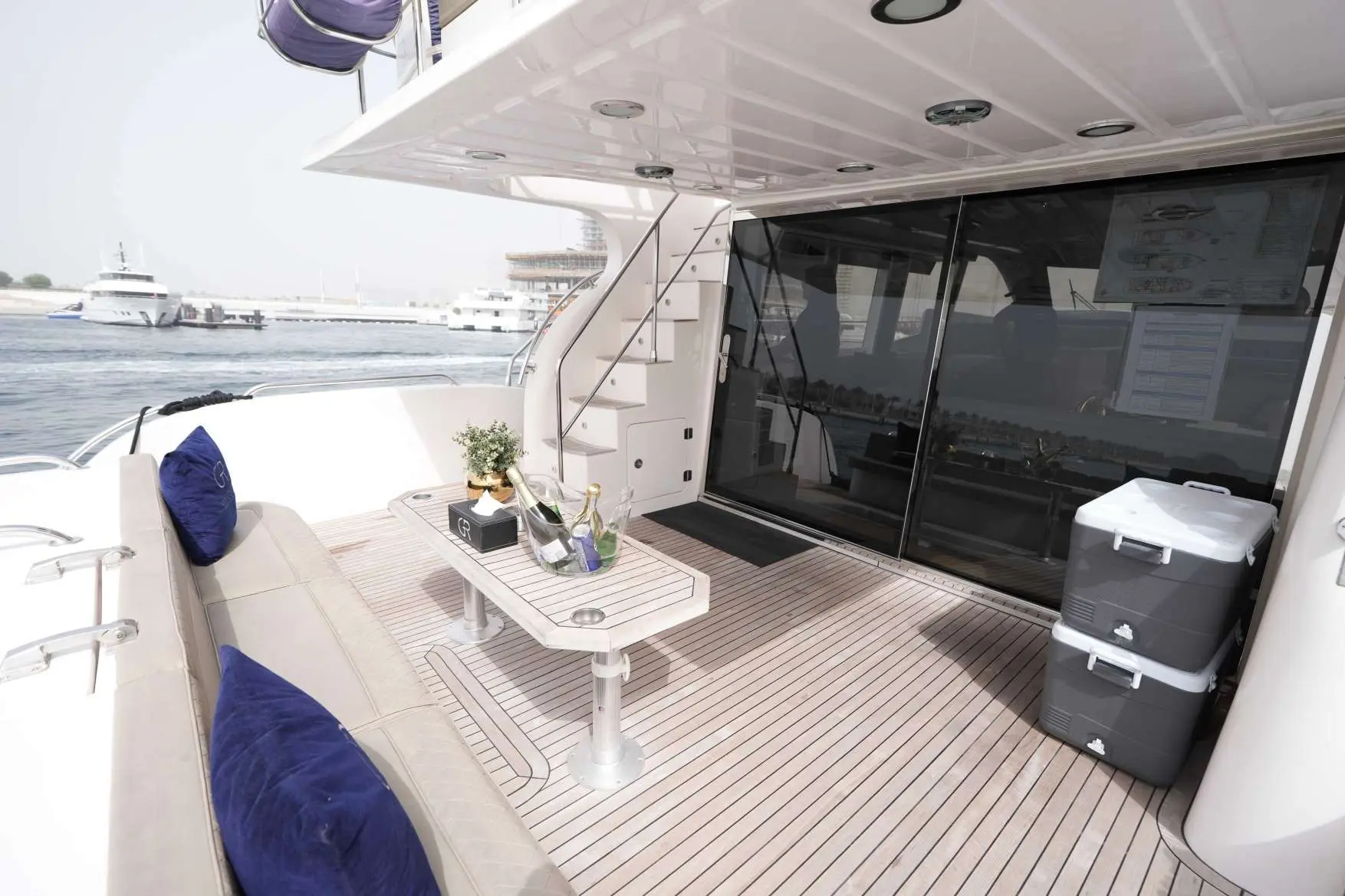 Belle 75 luxury yacht outdoor deck seating area with table and marina view