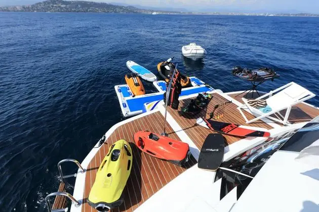 Baia 100 swim platform with water toys and tender alongside