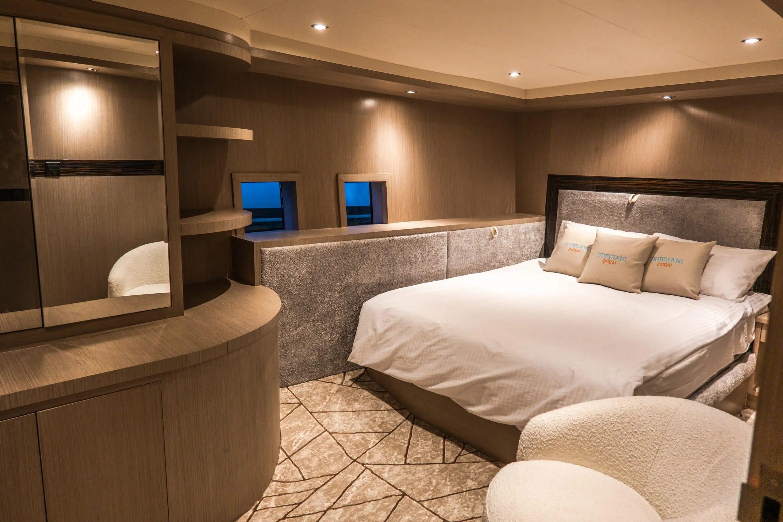 Modern yacht cabin with corner seating and a king-size bed