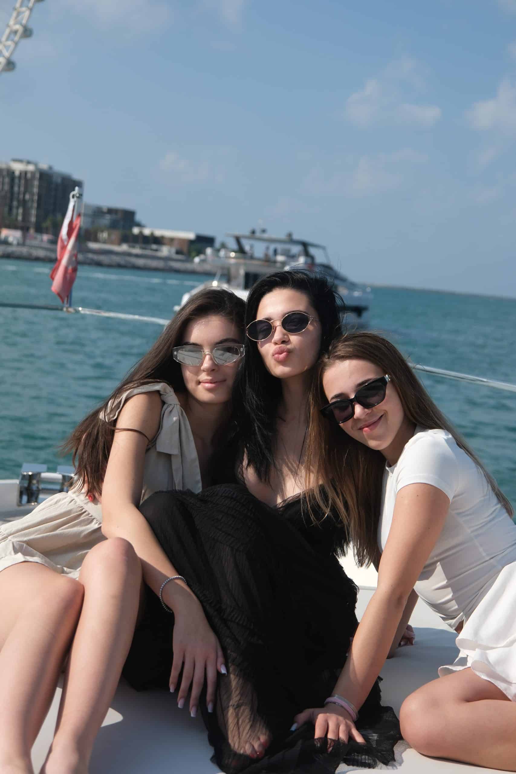 Friends relaxing on yacht bow during birthday yacht party in Dubai