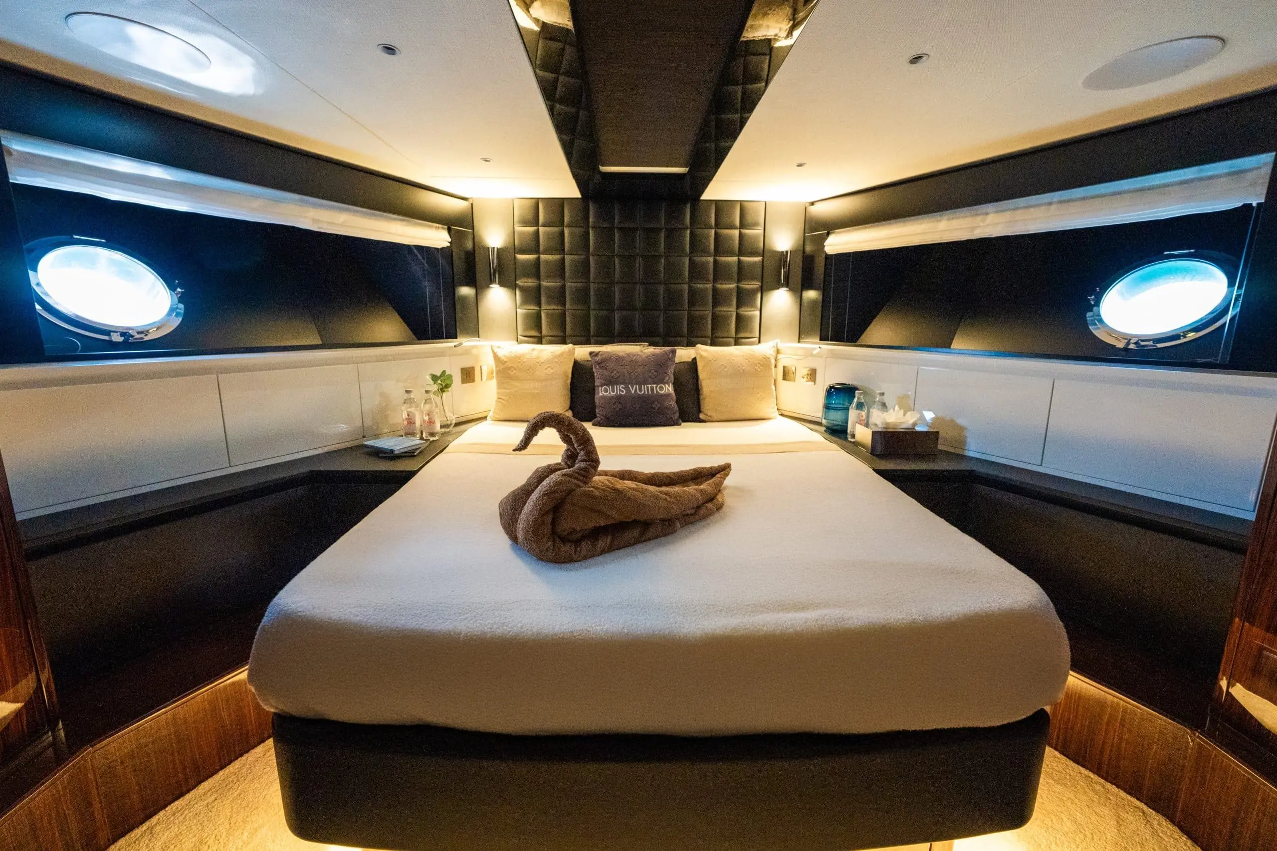 Luxury yacht master cabin with central bed and porthole windows