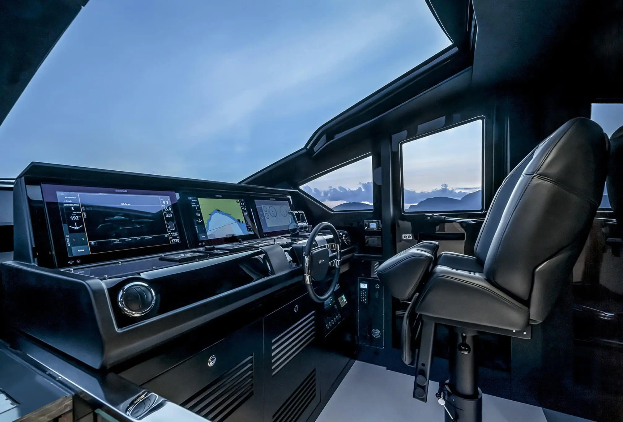Modern yacht helm station with digital navigation displays and captain’s chair