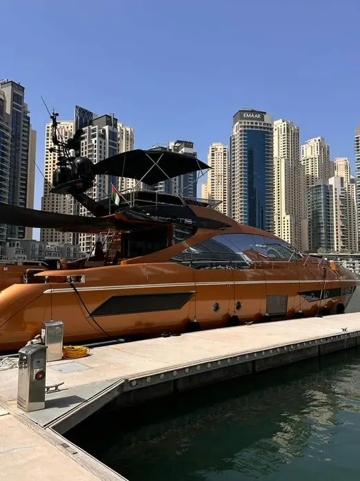 Azimut 77 yacht docked at marina with modern skyline backdrop