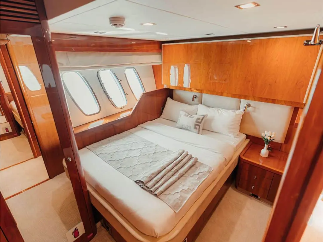 Guest bedroom on Notorious yacht with double bed and wooden interior