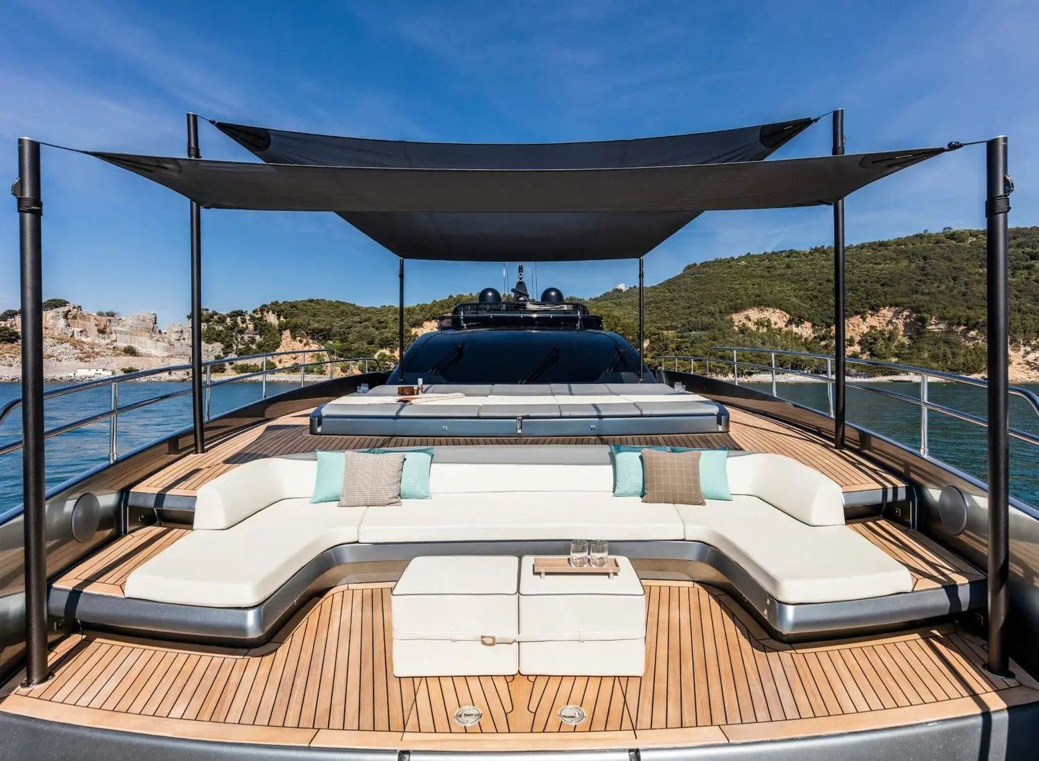 Riva 100 Corsaro foredeck lounge with sunpad under bimini shade