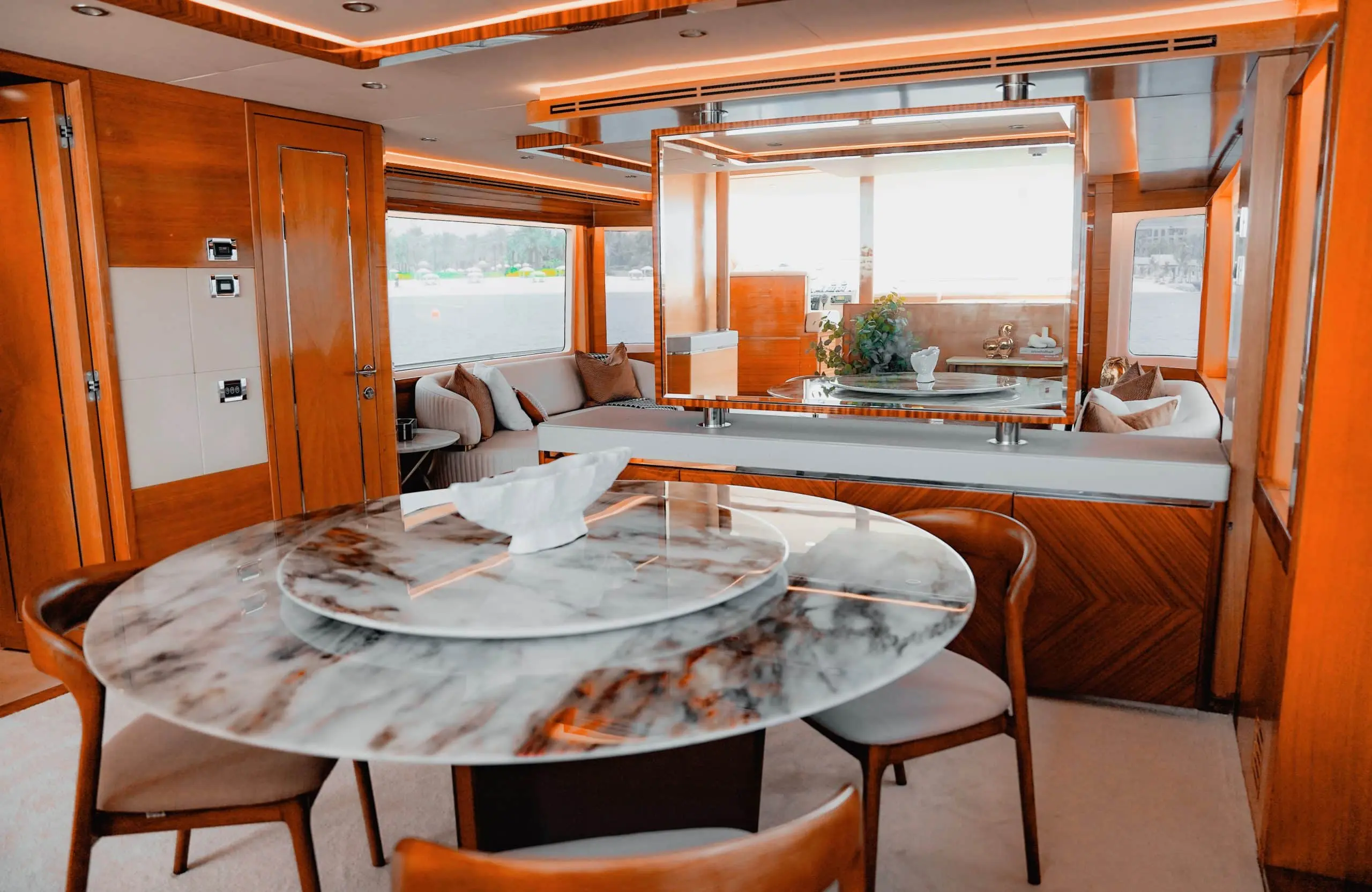 Interior dining and lounge area onboard Carina 75 yacht with marble table and panoramic windows