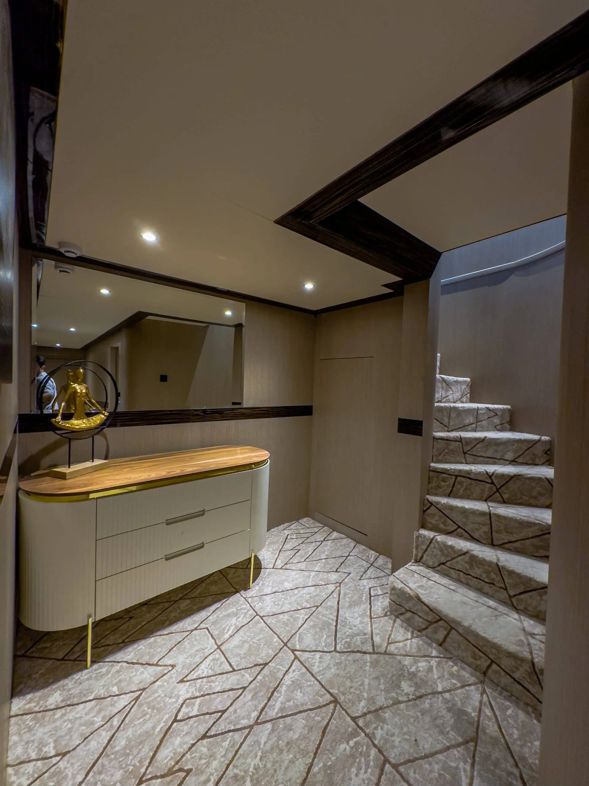 Modern yacht interior with staircase and vanity counter under warm lighting