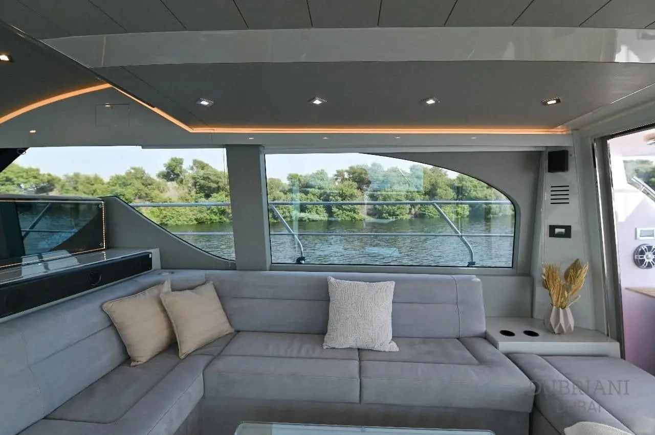 Grey L-shaped salon sofa on the Novia 55 beneath panoramic windows looking out over the water