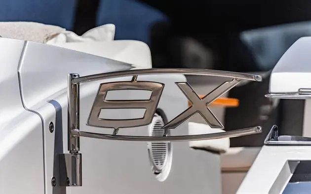 Pershing 8X chrome model badge on polished stainless rail detail